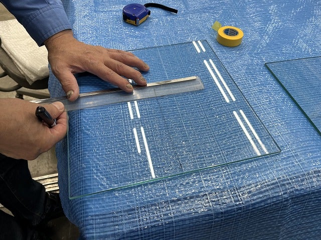 ガラスに位置出しをしています